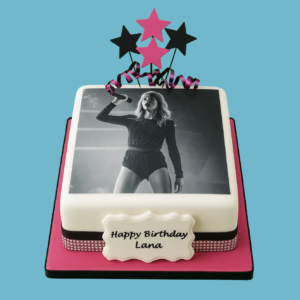 A square celebration cake featuring a high-quality printed image of a popular celebrity on top, designed as a personalised centrepiece for special occasions. The cake includes a customisable message plaque and is decorated with star-shaped toppers to enhance the glamorous theme. Ideal for birthdays, achievements, or events, it offers both stylish presentation and delicious flavour.