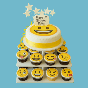 A vibrant Emoji Cake & Cupcake Tower featuring a round cake on the top tier with a large smiling emoji face, surrounded by multiple tiers of cupcakes, each decorated with different emoji expressions like heart-eyes, laughing, and winking faces. A personalised message plaque sits at the base of the main cake, and star-shaped toppers add festive sparkle throughout the display. The tower is colourful, fun, and perfect for birthdays or group celebrations, offering a playful and expressive centrepiece for guests of all ages.