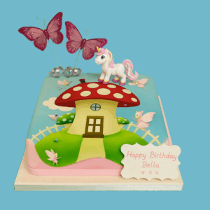 A square fairy-themed cake featuring a red and white toadstool house with a wooden door, set in a whimsical garden scene. Surrounding the toadstool are edible decorations including a unicorn, pastel butterflies, flowers, and moss-like textures. A personalised message plaque sits at the front, and miniature star and floral toppers add a magical touch. Soft pinks, greens, and creams complement the bold red, creating an enchanting design perfect for fairy-themed birthdays or garden parties.