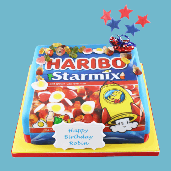 A square Haribo Starmix Sweetie Cake styled to look like a Haribo Starmix sweet bag, with a vibrant edible image of the packaging on top. Colourful fondant decorations shaped like jelly bears and cola bottles are placed on the cake, echoing the sweets inside the real pack. A personalised message plaque is displayed on the front, and star toppers add a festive flair. The design is bright, cheerful, and playful, making it ideal for birthdays and sweet-themed celebrations for all ages.