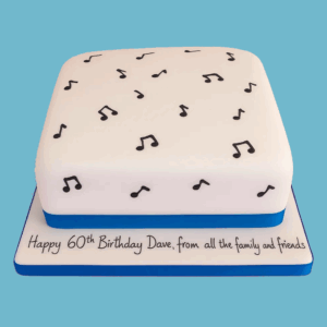 A square Musical Notes Cake with a smooth white fondant surface, decorated with scattered black musical symbols like treble clefs and quavers. A soft blue ribbon wraps around the base, adding a touch of colour to the black and white design, creating an elegant centerpiece for music-themed celebrations.