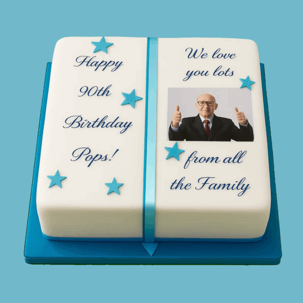 Rectangular personalised photo cake designed to resemble an open book, with a central space for a photo. The cake features smooth white fondant, elegant blue text, ribbon-like details, and blue star decorations. A custom message plaque is included, and the design is suited for birthdays, graduations, and special occasions.