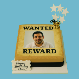 Personalised photo cake with a “Wanted” poster design, featuring a custom photo framed in black on a light brown fondant base. The cake has a scalloped edge and is topped with star decorations and a message plaque. Playful and creative, it’s designed for birthdays or special celebrations, with space for personalised text and available in various flavours and sizes.
