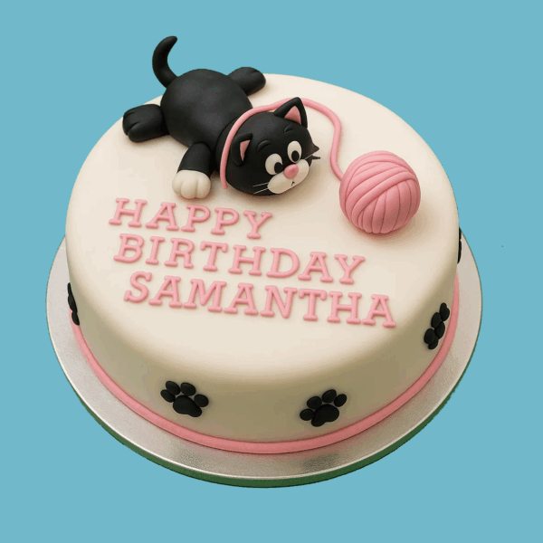 A round cake with smooth white icing and pink piped edges, decorated with black paw prints around the sides. On top lies a cute black and white fondant kitten on its back, playfully reaching for a pink fondant ball of wool connected by a thin string. Pink lettering on the cake’s surface displays a personalized message. This charming cake is designed for celebrations and can be customized in size and flavor.