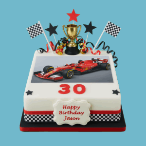 A square Racing Car Cake featuring a vivid, action-packed image of a racing car on the top surface, set against a dynamic background with racing flags. A shiny 3D trophy topper stands prominently on top, surrounded by bright, colorful star-shaped decorations along the edges. A personalized message plaque is placed on the front of the cake, allowing for custom names or birthday greetings. The design captures the energy and excitement of motorsports, making it a fun and bold centerpiece for racing-themed celebrations and children’s birthdays.