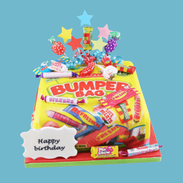 A square Swizzels Bumper Bag Sweetie Cake designed to mimic the iconic yellow Swizzels packaging, topped with colourful fondant replicas of popular Swizzels sweets. The bright yellow icing serves as a base for the vibrant sweet decorations, creating a cheerful and nostalgic appearance. A personalised message plaque is placed at the front, and star-shaped toppers add a festive finish. This playful and eye-catching cake is ideal for birthdays and celebrations, offering both visual appeal and a fun tribute to classic sweets.