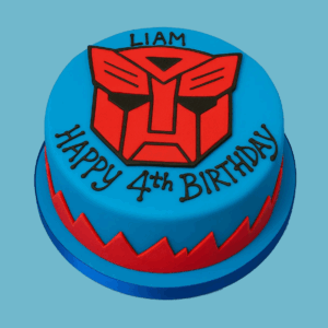 A round cake decorated with the bold red Transformers Autobot logo centered on a rich blue background. The sides feature a jagged red and blue pattern that adds dynamic energy to the design. The cake serves as a vibrant and striking centerpiece, perfect for Transformers fans, with customizable sizes and flavor options.